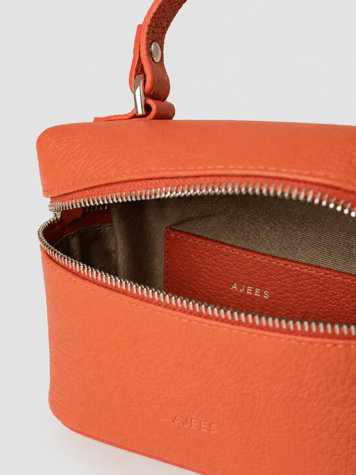 Premium orange leather vanity box handbag with top handle and dual zipper closure for women