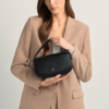 "Black premium leather saddle shoulder bag with curved handle, adjustable shoulder strap, and buckle detail - versatile women's crossbody bag"
