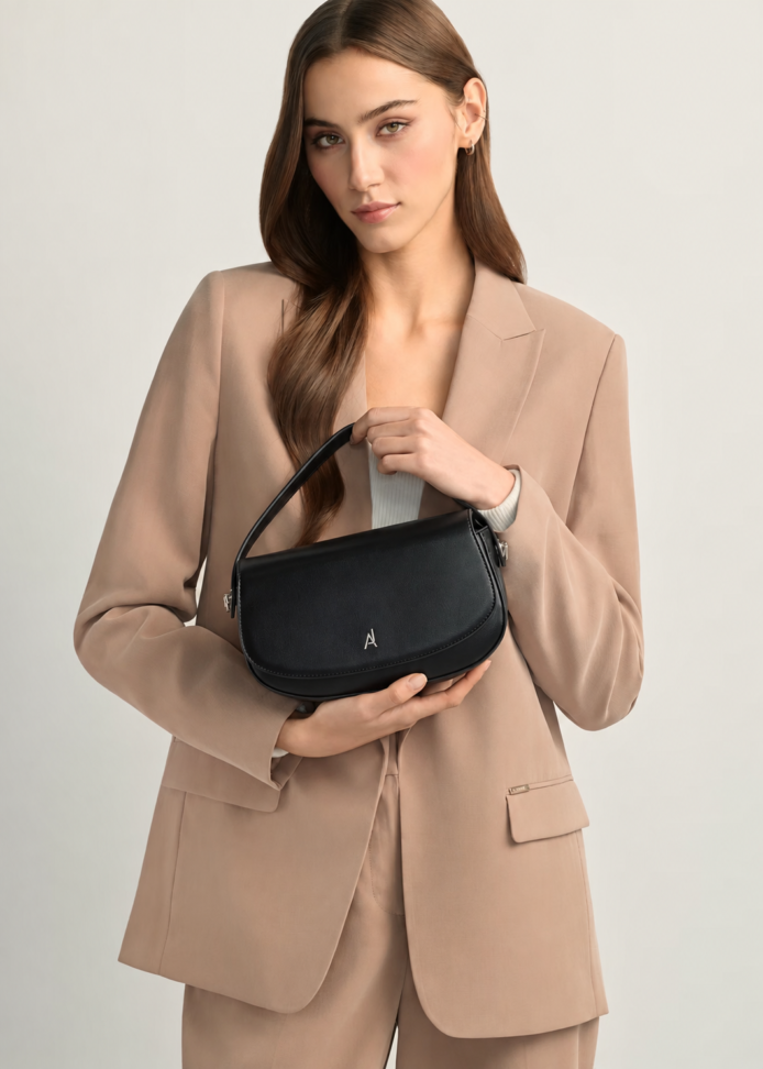 "Black premium leather saddle shoulder bag with curved handle, adjustable shoulder strap, and buckle detail - versatile women's crossbody bag"