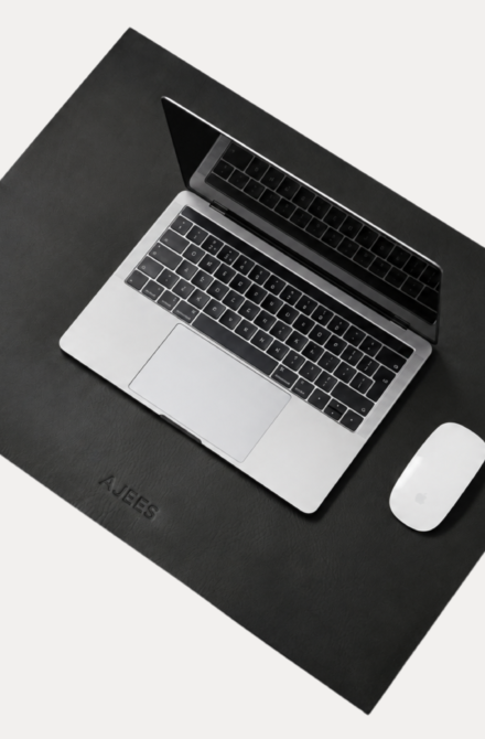 AJEES Premium Leather Desk Mat with laptop and mouse on a black leather office desk mat.