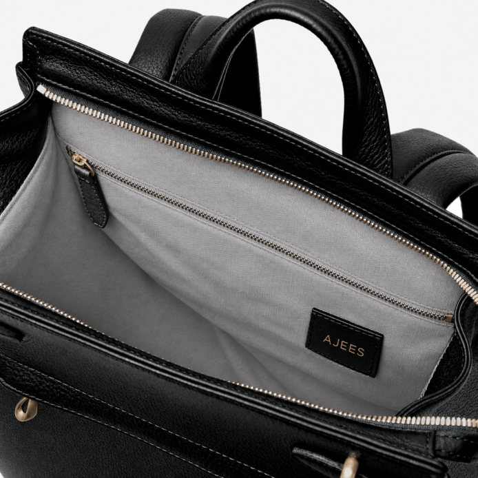 Close-up of the Noble backpack top latch closure and brass hardware detailing.