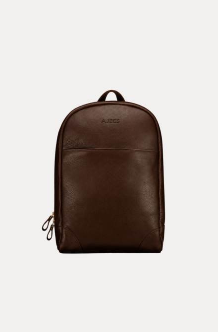Image 1 (front view): Zenvik brown leather backpack with embossed AJEES logo, brass zippers and top carry handle