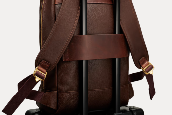 Image 1 (front view): Zenvik brown leather backpack with embossed AJEES logo, brass zippers and top carry handle