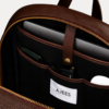 Image 1 (front view): Zenvik brown leather backpack with embossed AJEES logo, brass zippers and top carry handle